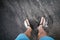 Man looking down at feet and sandals on volcanic black sand beac