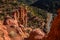 Man looking down over dangerous cliff near Saint George, Utah among red rock towers