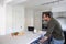 Man looking in drawer whilst preparing food and working from home