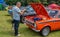 Man looking at the engine bay of a Ford Mexico rally car