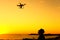 Man looking on flying drone in sunset