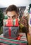 Man Looking Over Stacked Christmas Gifts In Store