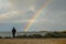 Man looking at a rainbow over the sea