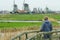 Man looking at rural landscape view with traditional Dutch windmills and old farm houses