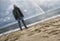 Man looking at the sea and rainbow