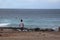 Man looking at the sea where surfers ride the waves