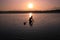 A man Looking for Shellfish at Low Tide in The Sunset time, Wading in Water