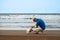 Man looking to his dog at the beach