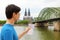 Man looking to his paper map in his hand with Cologne Cathedral and bridge on Rhine river, Germany. Travel in Europe.