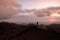 Man looking volcanic cone at sunset by wild camp in Etna Park