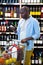 Man looking at wine bottle in grocery section