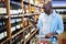 Man looking at wine bottle in grocery section