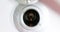 Man looks through a house or hotel peephole of white door with his hand, zoom in and zoom out camera movement, check security