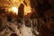 A man looks at the large stalagmite in the limestone cave