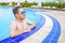 Man looks out of pool, hanging on the railing.