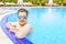 Man looks out of the pool, hanging on railing.