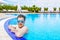 A man looks out of the pool, hanging on the railing