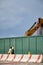 Man looks through a provisional fence window at a construction site