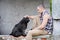 Man looks at a stray dog and keeps a hand on the dog\'s head.