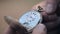 A man looks at the time of old pocket watches and closes them. Close up