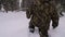 A man lost in a winter forest walks through deep, loose snow.