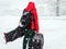 Man with luggage stands on the road of a ski resort during heavy snowfall