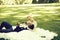 Man lying in arms of cute bride on green grass