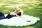 Man lying in arms of cute bride on green grass