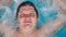 The Man is Lying Relaxes in the Jacuzzi and Looks at the Camera. Caucasian Man Resting in a Pool Lies on Water. View