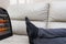 Man lying on sofa with electric heater near his feet