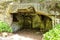 Man made cave with recesses and foliage on the floor