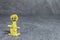 Man made of yellow play dough in front of grey background