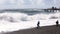 Man makes a dangerous self during a storm on the sea against a giant wave