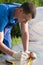 A man makes measurements of a plastic transparent cover for the greenhouse, close-up