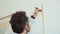 Man makes measurements with ruler and pencil on wall