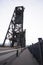 Man makes photograph of old truss transportation bridge with lifting towers Portland down town Willamett river