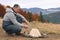 Man making bonfire in mountains. Camping season