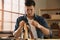 Man making holes in leather belt with stitching awl