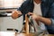 Man making holes in leather belt with stitching awl at table