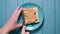 Man making a peanut butter sandwich. Blue background. Top view.