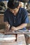 Man making shell inlay-ed furniture.