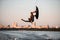 man making trick in jump time with wakeboard on sky background.