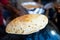 Man making an ulta tawa paratha bread on an upturned pot mughal cuisine from india and pakistan