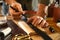 Man marking holes on leather belt in workshop, closeup