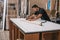 Man marking with pencil the lines to cut on a panel in a workshop