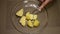 Man mashes potatoes in a glass bowl