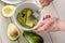 Man mashing avocado slices in a bowl with a fork