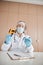 Man in mask and labcoat with a contactless thermometer