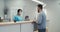 Man in mask speaking with nurse on hospital reception