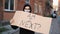 Man in mask stands with cardboard poster in hands - AM I NEXT AND STOP RACISM